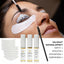 Lashes fixed on a silicone pad during a lash lift, with the kit bottles and pads